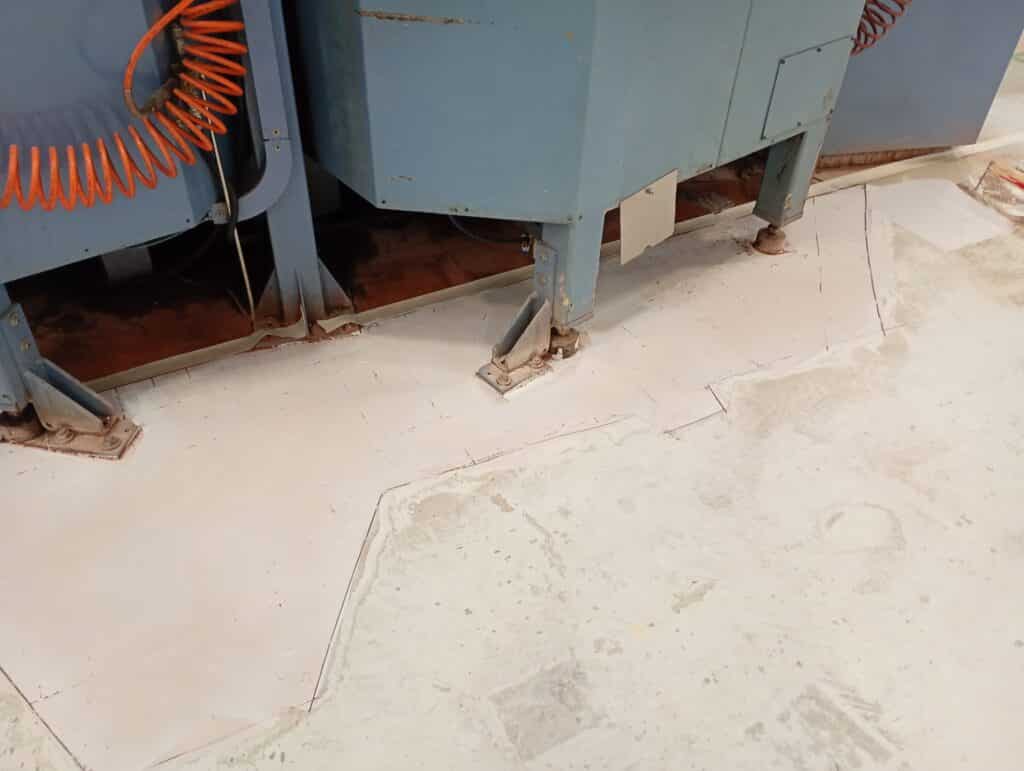 Fase di preparazione meccanica e applicazione primer su pavimento industriale