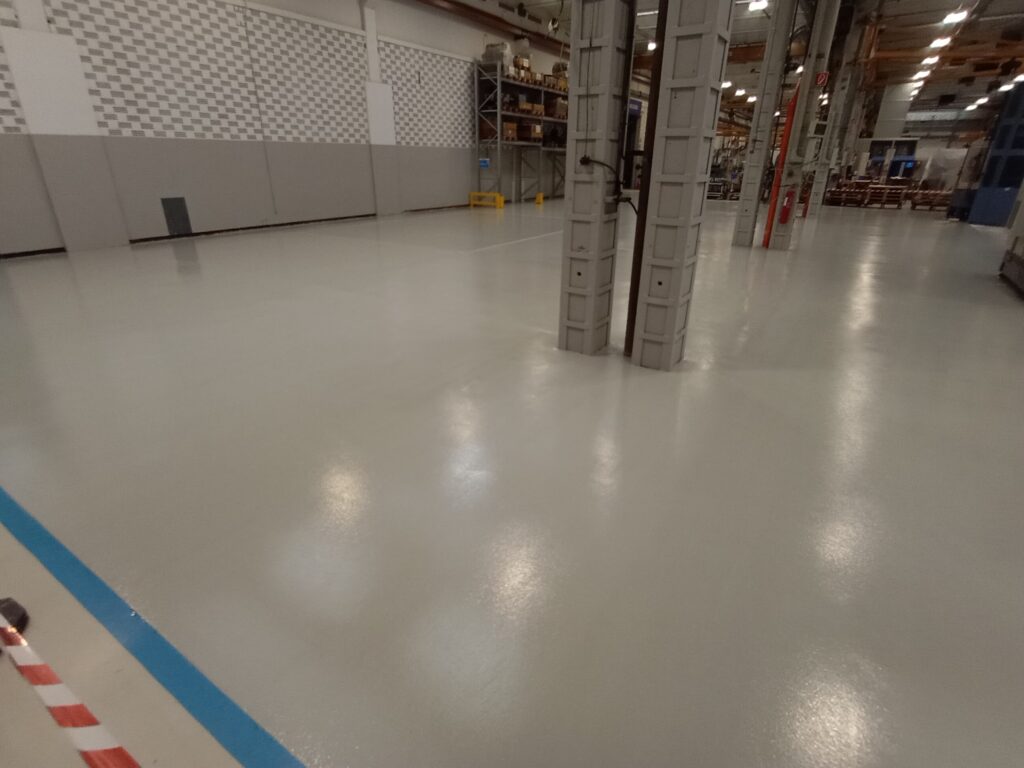 Pavimento in resina industriale ripristinato e finito color grigio