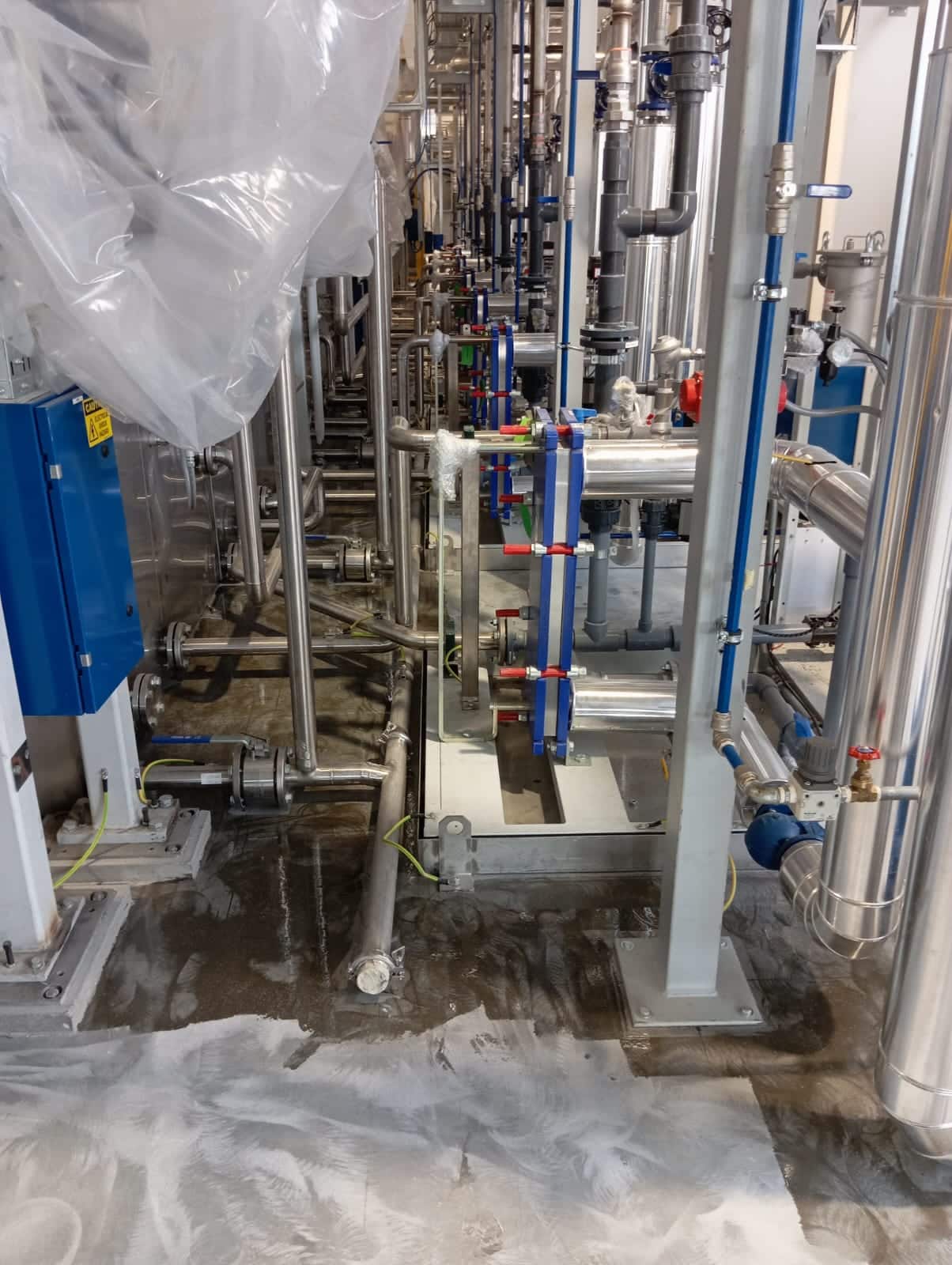 situazione pre intervento: pavimento in cemento grezzo tra tubazioni industriali