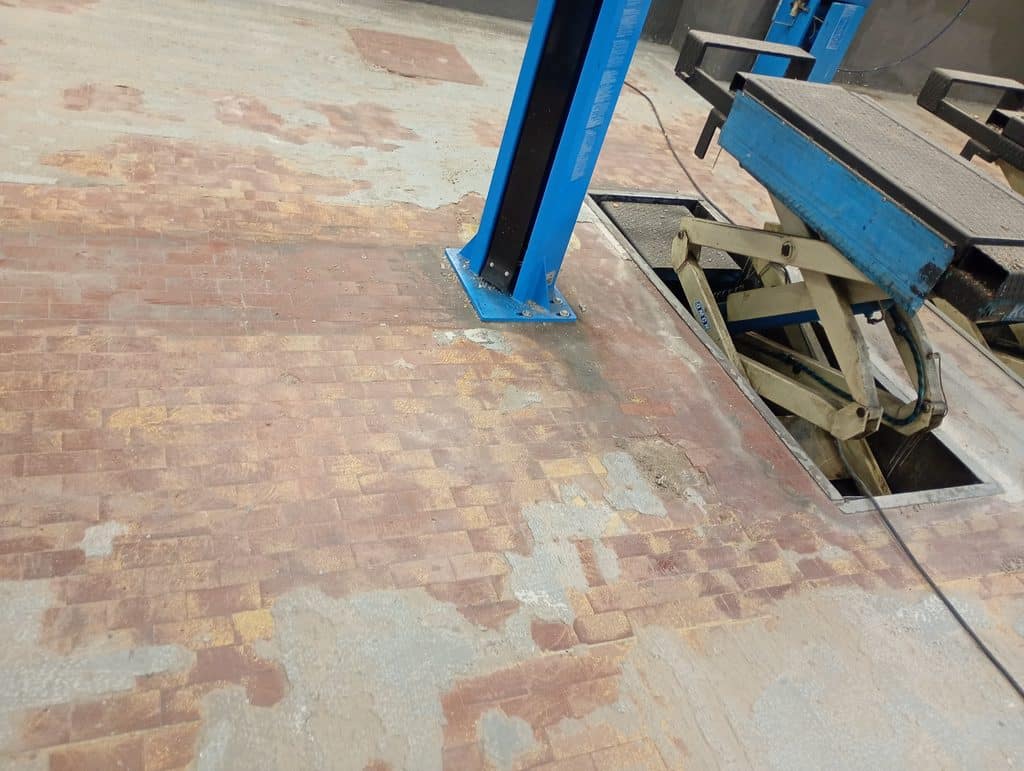 Pavimento officina ammalorato con piastrelle e massetto sbriciolato impregnato di olio - Milano